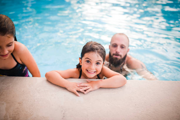 istock Fun in the pool, father and two daughters 1131203423