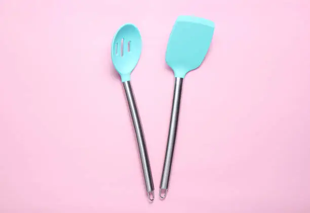 Silicone paddles for cooking on pink background. Top view."n