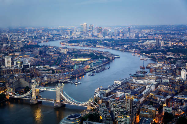 Aerial view of Tower Bridge and Canary Wharf skyline at night Aerial view of Tower Bridge and Canary Wharf skyline at night southwark stock pictures, royalty-free photos & images