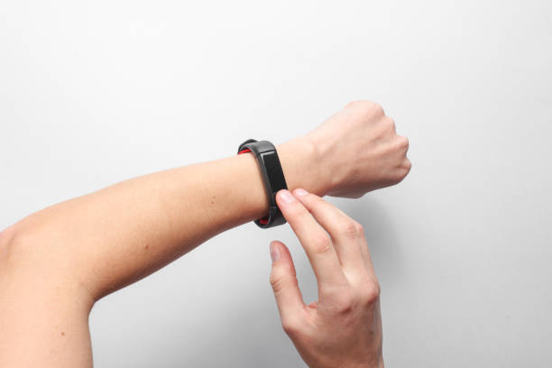 Women's hands use smart watch on gray background. Modern gadgets, top view