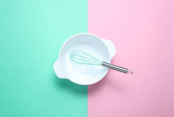 istock White empty bowl with a whisk on a pastel colored background. Top view, minimalism 1131206433