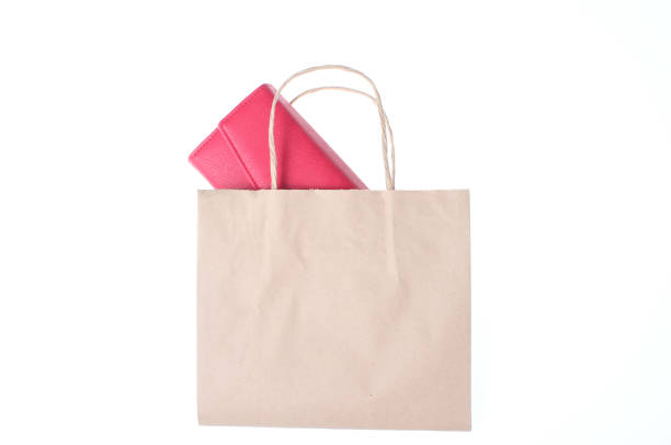 istock Red leather wallet on a paper shopping bag isolated on white background 1131206553
