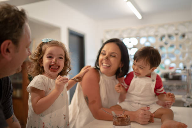 istock Family with twin sibling (Down Syndrome Boy and Girl) having fun eating chocolate 1131206899