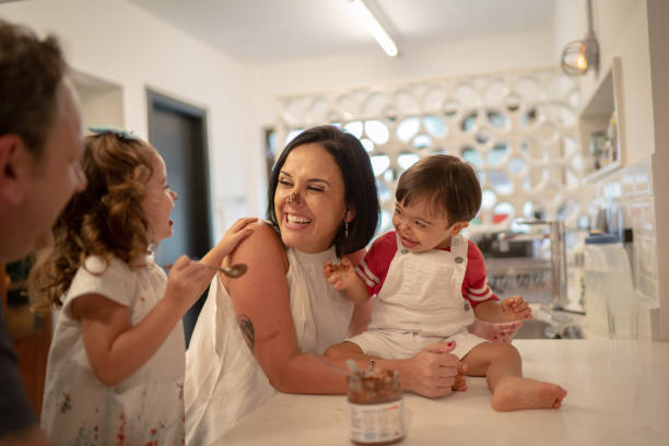 istock Family with twin sibling (Down Syndrome Boy and Girl) having fun eating chocolate 1131207024