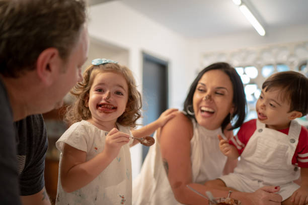 istock Family with twin sibling (Down Syndrome Boy and Girl) having fun eating chocolate 1131207026