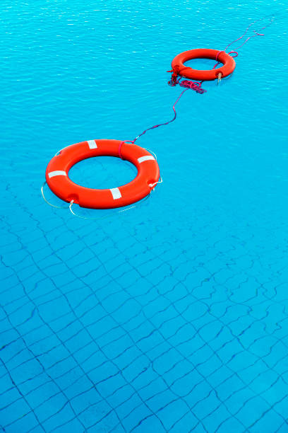 orange color life preservers floating in swimming pool in greece - life jacket isolated red safety imagens e fotografias de stock