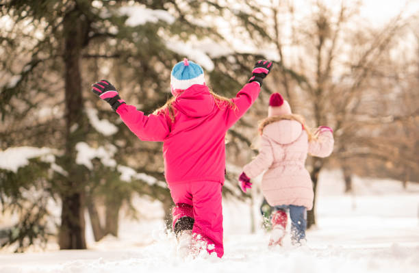 istock Rear view girls running on the snow 1131207203