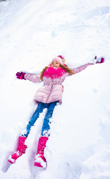 istock Cute girl making snow angel 1131208581