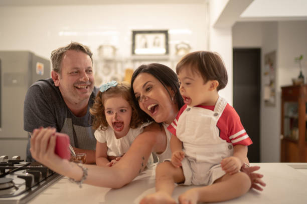 istock Family with twin sibling (Down Syndrome Boy and Girl) taking a selfie after eating chocolate 1131209010