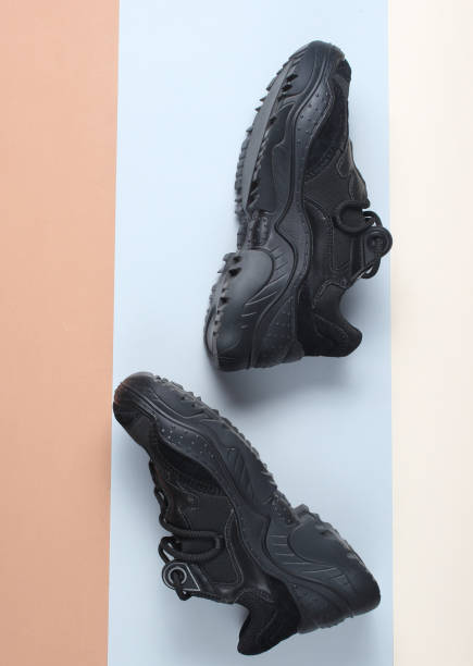 istock Black sneakers boots on a colored paper background. Top view. 1131211371