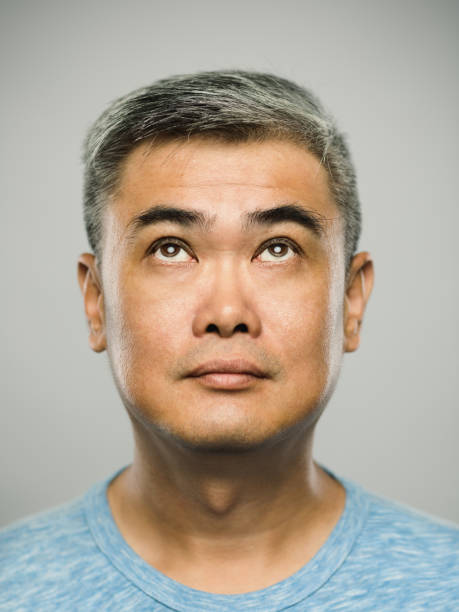istock Portrait of real chinese mature man with blank expression looking up 1131214636