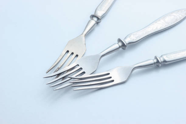 Old metal forks close-up on gray background.