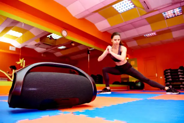 Portable acoustics in the aerobics room on the background of a blurred girl practicing sport.