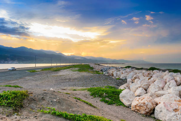 The Palisadoes peninsula in Kingston, Jamaica A section of The Palisadoes peninsula in Kingston, Jamaica with large rock boulders to help prevent flooding on the strip of land kingston harbour stock pictures, royalty-free photos & images