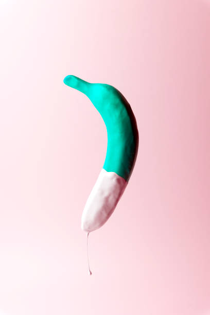 istock Colored banana in paint on a pastel background. Minimal concept. Minimal style. Flat lay. 1131221899