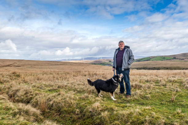istock Senior Caucasian man on Welsh moorland with dog 1131223633
