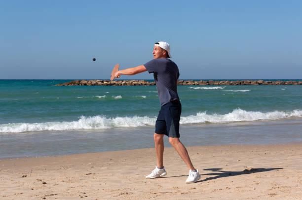 der mann, der tennis am strand spielt - activity asia atmosphere beach stock-fotos und bilder