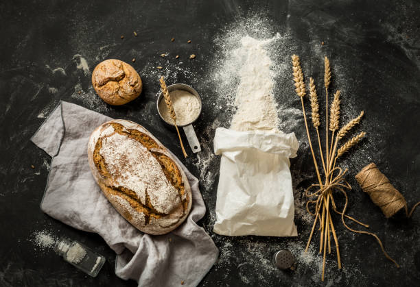 istock Bread, flour bag, wheat and measuring cup on black 1131224436