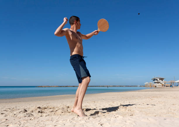 der mann, der tennis am strand spielt - activity asia atmosphere beach stock-fotos und bilder