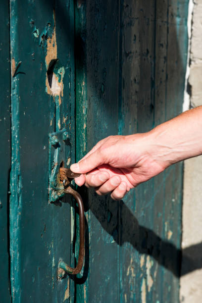 istock hand opens old wooden door with rusty key 1131225854