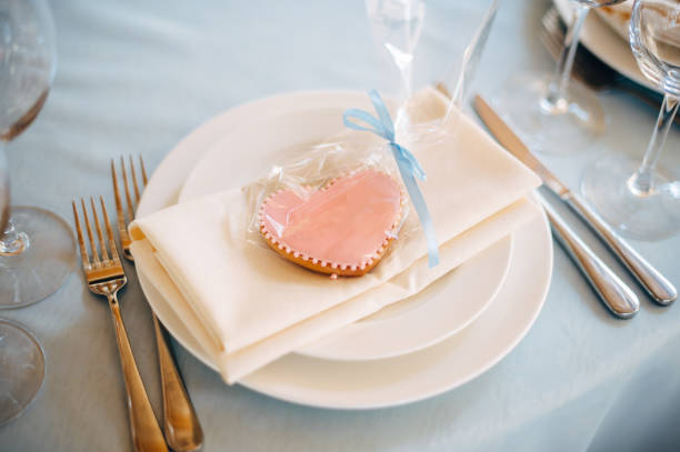 istock White plate on blue tablecloth, pink heart form cookies on plate 1131228487