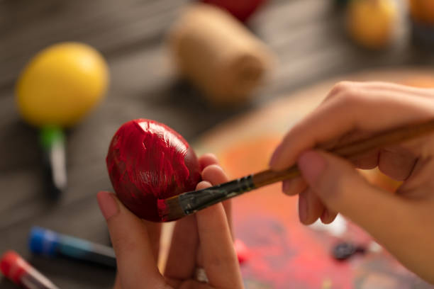 istock Hands holding and painting colorful easter egg 1131232020