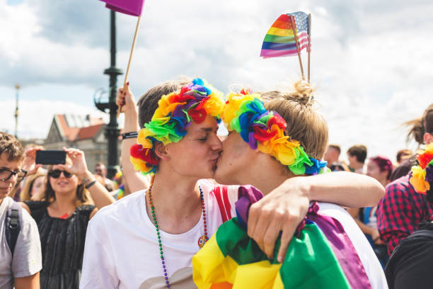 participants of the annual prague gay pride parade. gay couple kissing in a crowd. - flag rainbow gay pride flag gay man imagens e fotografias de stock