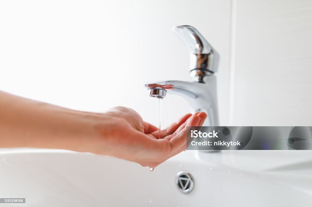 hand under faucet with low pressure water stream hand under faucet with low pressure water stream, close-up view Physical Pressure Stock Photo