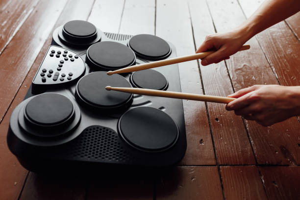 istock hands playing on portable electronic drums, brown background 1131238390