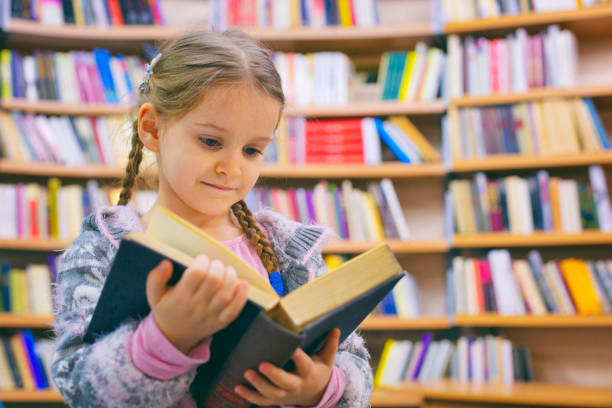 istock Girl reading book in library 1131243835