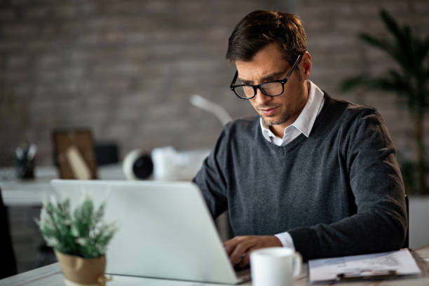 istock Male entrepreneur typing an e-mail while working on laptop in the office. 1131252464