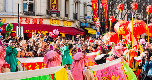 Paris, France - February 17, 2019. Last day of the chinese new year celebration festival in street. People dragon lion dancing show colorful costumes. 200 thousands, multi ethnic asian man woman. Year of pig