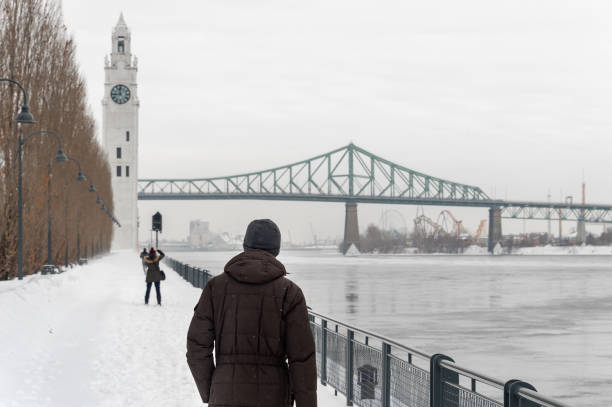 Montreal, CA - 21 February 2019: St. Lawrence River, Clock tower and Jacques Cartier Bridge in the Old Port in winter.
