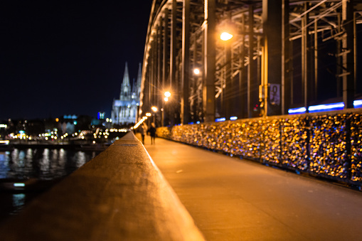 Long exposure shot of Hohenzollern bridge in Cologne with Cologne Cathedral in background and blurred people moving