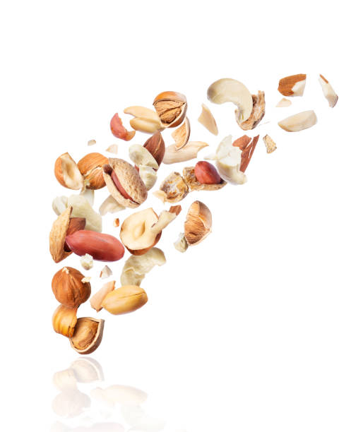 istock Various nuts crushed in the air on white background 1131261783