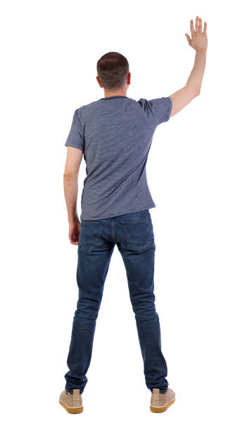 istock Back view of a man in jeans points his hand upwards. 1131263794