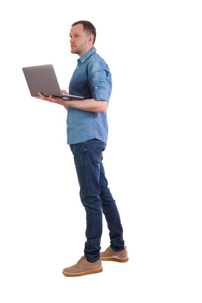 istock Back view of a man who is standing with a laptop. 1131263942