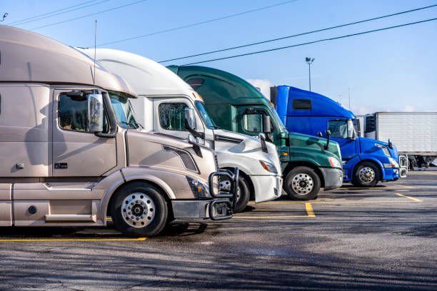 istock Different big rig semi trucks standing in row on truck stop ready to go 1131269501