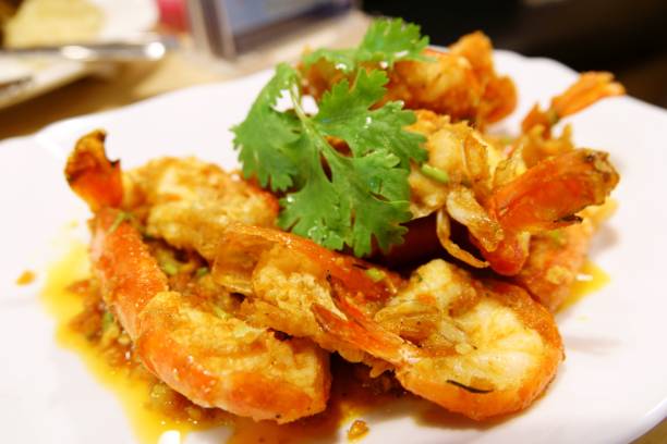 istock Stir-fried prawns with garlic and pepper on white dish close up 1131273556