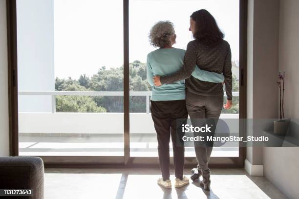 Rear View Of Happy Mother And Daughter Standing Embracing Stock Photo - Download Image Now