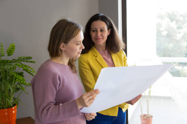 istock Female architect showing house design drawing to customer 1131277427