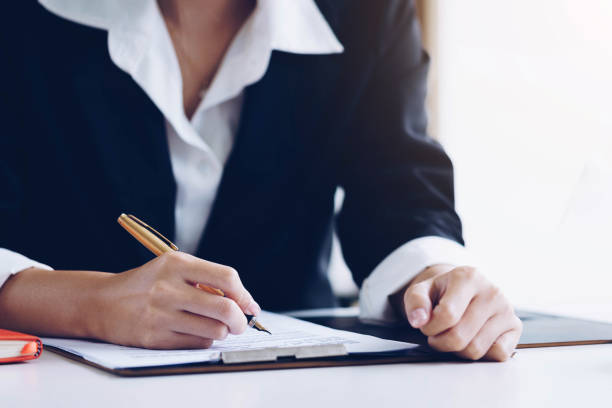 istock Secretary in suit at workspace reading and working with documents on white desk. Business finances and Secretary concept. 1131278222