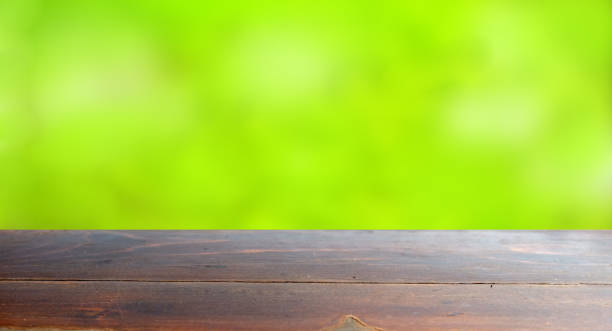 istock Empty wood table top on blur abstract green from garden in morni 1131278287