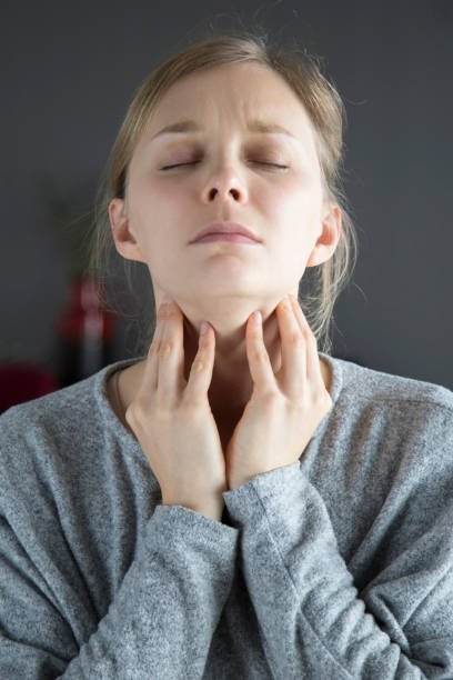 Sick woman with closed eyes having sore throat, touching neck