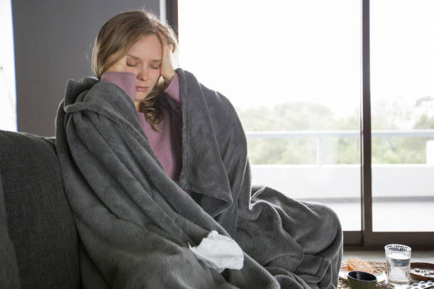 istock Sick young woman having headache, massaging head with fingers 1131278600
