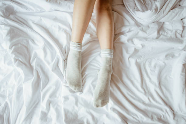 istock Slim and charming crossed woman legs on bed. 1131280125