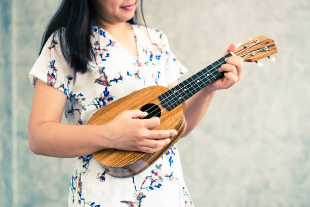 istock Happy woman musician playing ukulele in studio. 1131285155