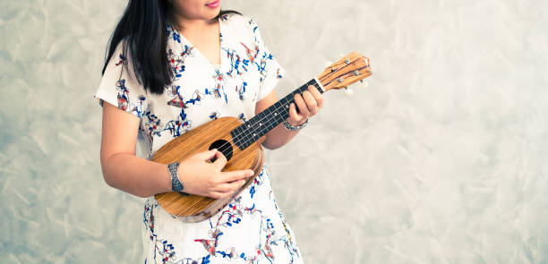 istock Happy woman musician playing ukulele in studio. 1131285227