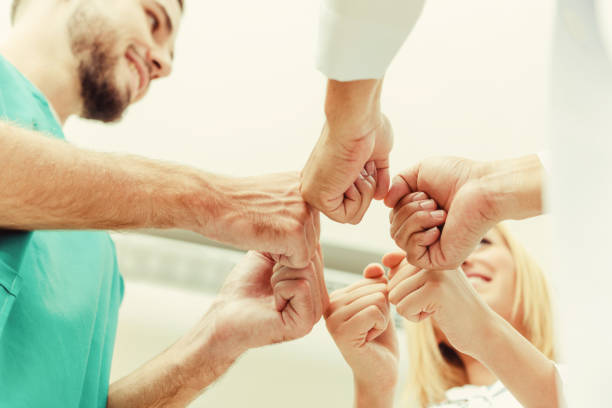 istock Doctor, surgeon and nurse join hands together. 1131286862
