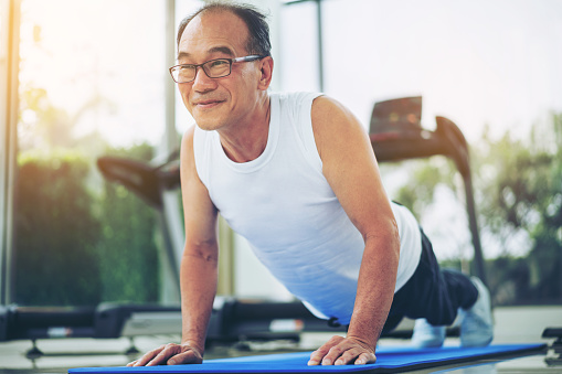 Senior man push up in fitness gym.